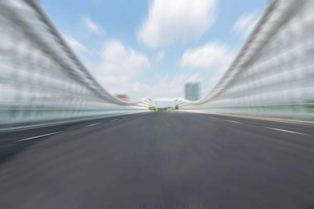 motion blurred asphalt road on the bridge in downtown with cloudy sky. copy space for car advertisement.