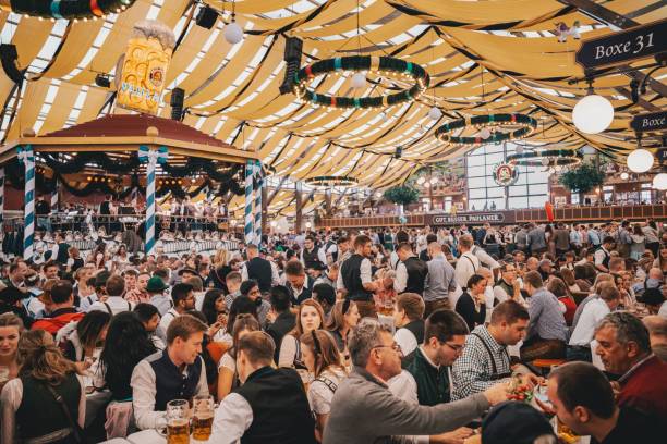 menschen sitzen im bierzelt auf dem oktoberfest münchen. - pretzel oktoberfest german culture beer stock-fotos und bilder