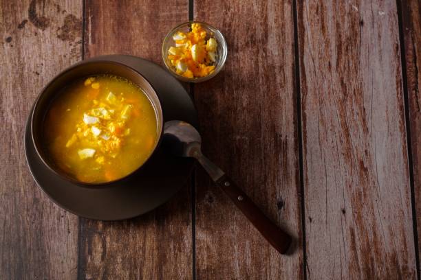 istock chicken noodle soup in a brown bowl with spoon and hard boiled egg 1442913139