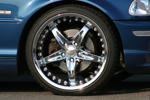 Custom chrome wheel and tire on blue sport sedan