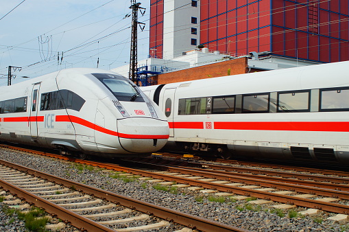 Frankfurt, Germany – August 12, 2021: An ICE 4 is heading Frankfurt Central Station while an ICE 1 is leaving in the background. Meeting of the generations in front of power station west.