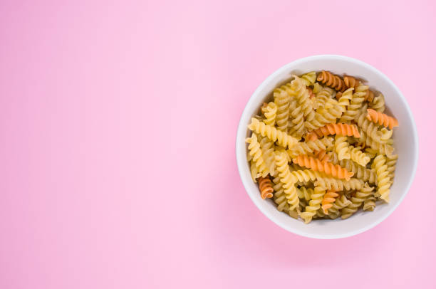 istock Top view of little white pottery with colored pasta isolated on 1442914905