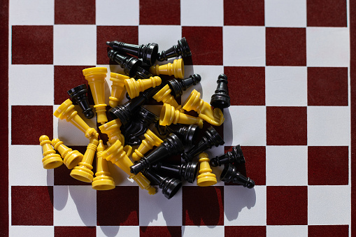 A top view of chess pieces scattered on the board