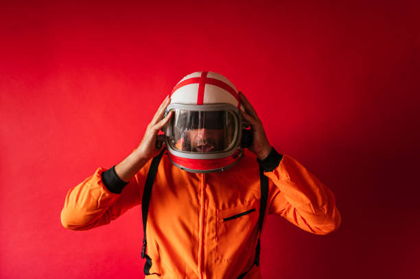 istock Astronaut with a helmet and an orange space suit on a red background 1442917350