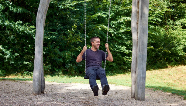 istock Hispanic man sitting on a swing in a park 1442918796