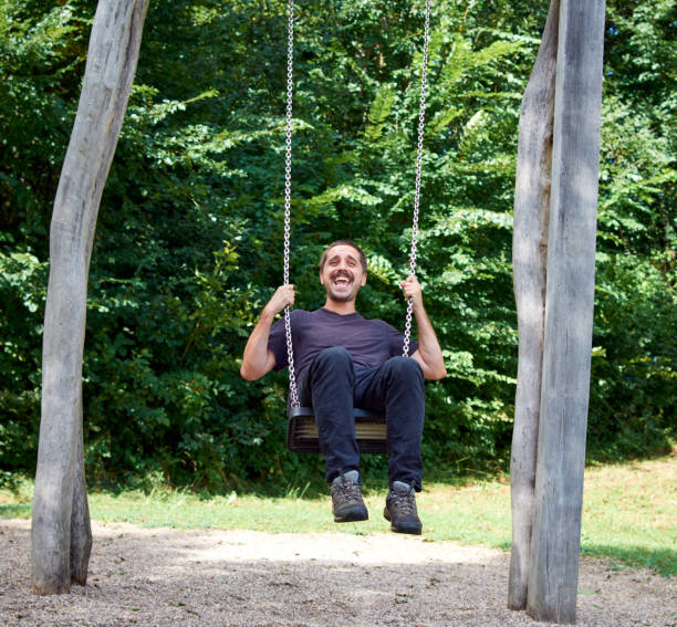 istock Young Hispanic man on a swing in a park 1442918801