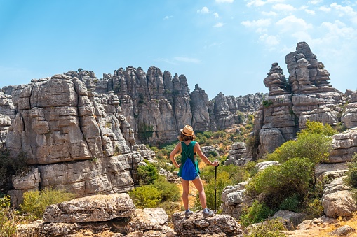 A back view of a woman standing on the rock and looking at the landscape of Torcal de Antequera