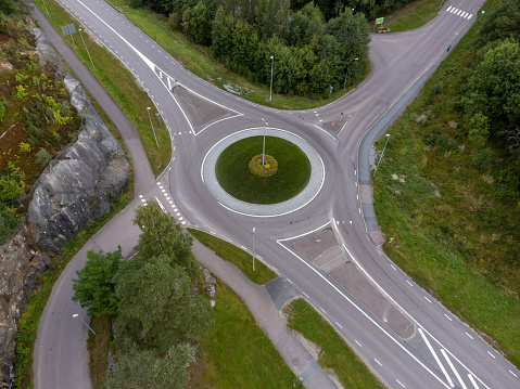 Bird's eye view of a traffic roundabout, roads, lanes with no cars and a path in Partille.  Aerial, drone photography taken from above in Sweden.