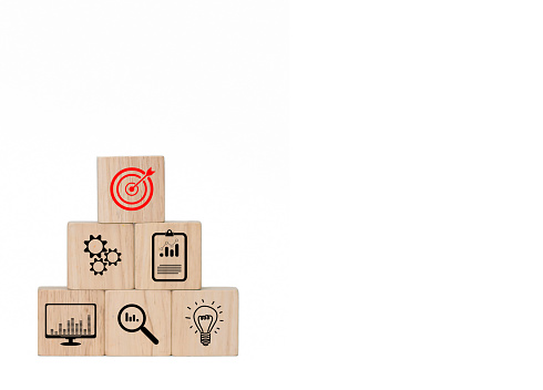 Square wooden blocks depict business goals, red target symbols, light bulbs represent ideas, glasses symbols represent searches,
On a white background, leave a blank space to insert text for promotional materials, pictures taken and edited in Photoshop by Thai people for everyone