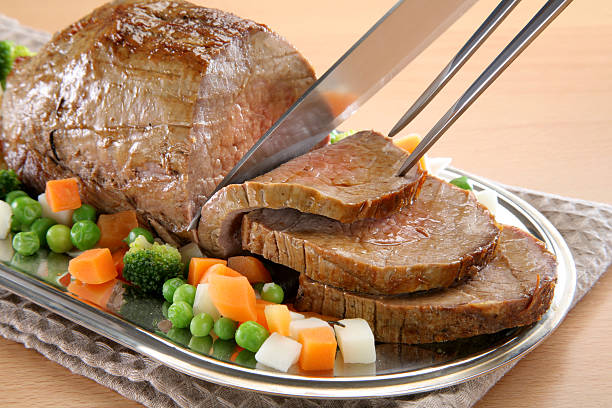 Sliced roast beef with broccoli, carrots and peas