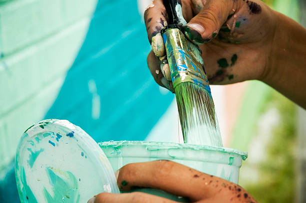 Painter's Hands Close-up of muralist painting mural stock pictures, royalty-free photos & images