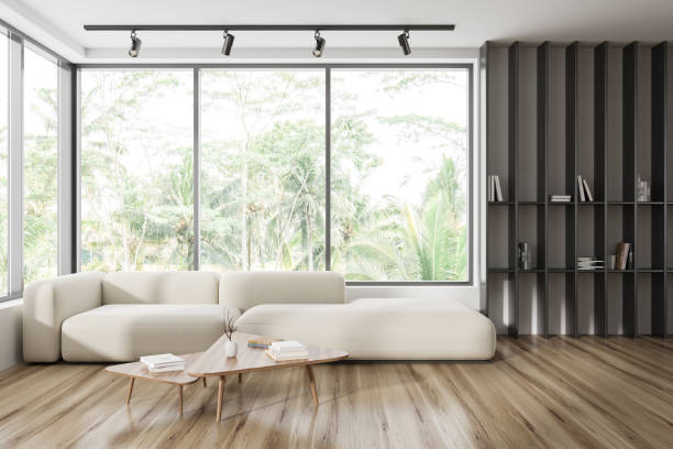 istock Light guest room interior with couch and shelf with books, panoramic window 1442932651