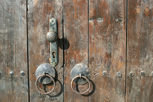 Old weathered wooden door with iron door handle on a traditional bulgarian house.