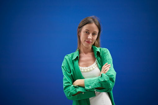 Portrait Smiling confidence European woman  against blue background