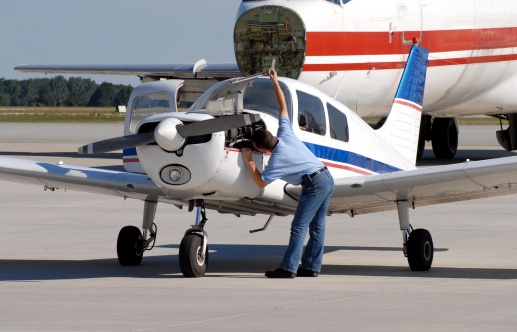 pre-flight inspection of the airplane by male flight student