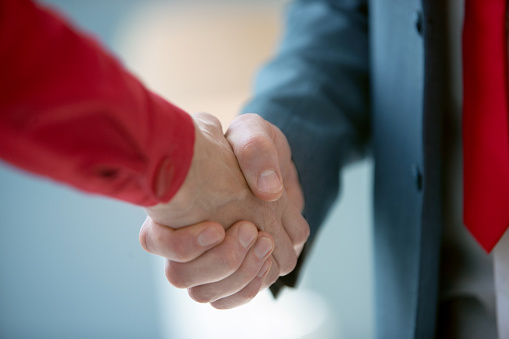 Unrecognizable business people shaking hands, shaking on agreement