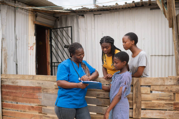 общинная медсестра разговаривает с девочками-подростками в неформальном поселении перед лачугой - africa south africa child african culture стоковые фото и изображения