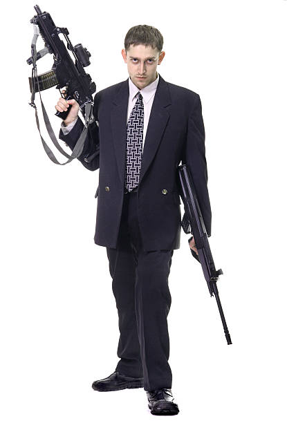 Young purposeful manager with dollars in pocket and weapon stock photo