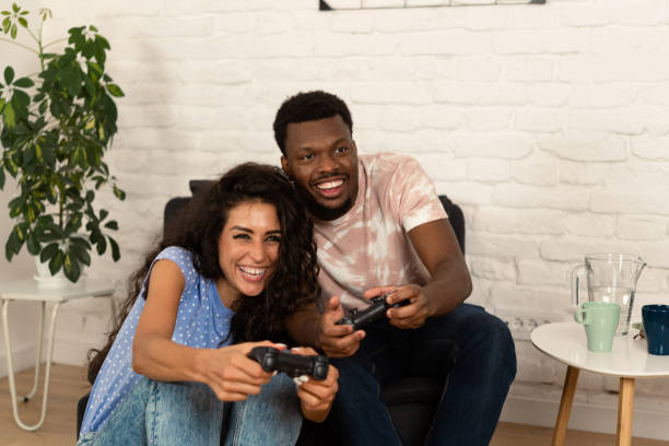 istock Excited multiracial couple having fun playing video games 1442940284