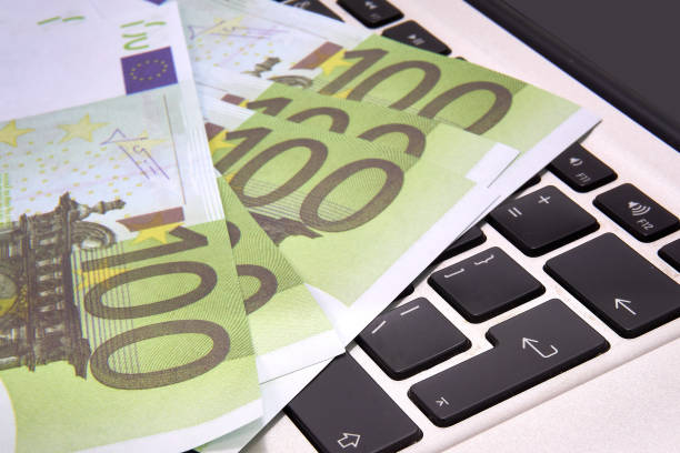 istock 100 euro bills lying on a computer keyboard, close-up 1442940668