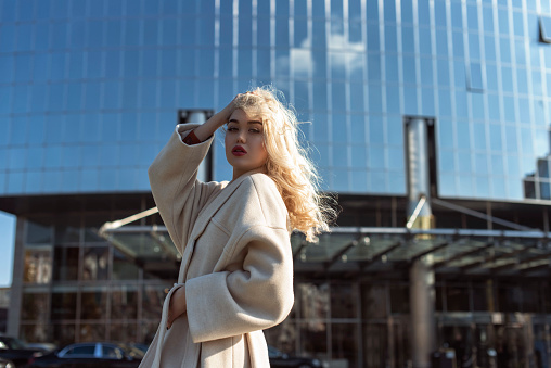Young blonde woman in autumn city