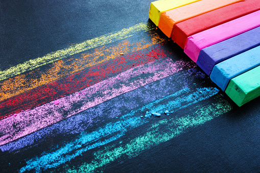 Crayones multicolores en una pizarra negra como símbolo de creatividad. Fondo colorido. photo