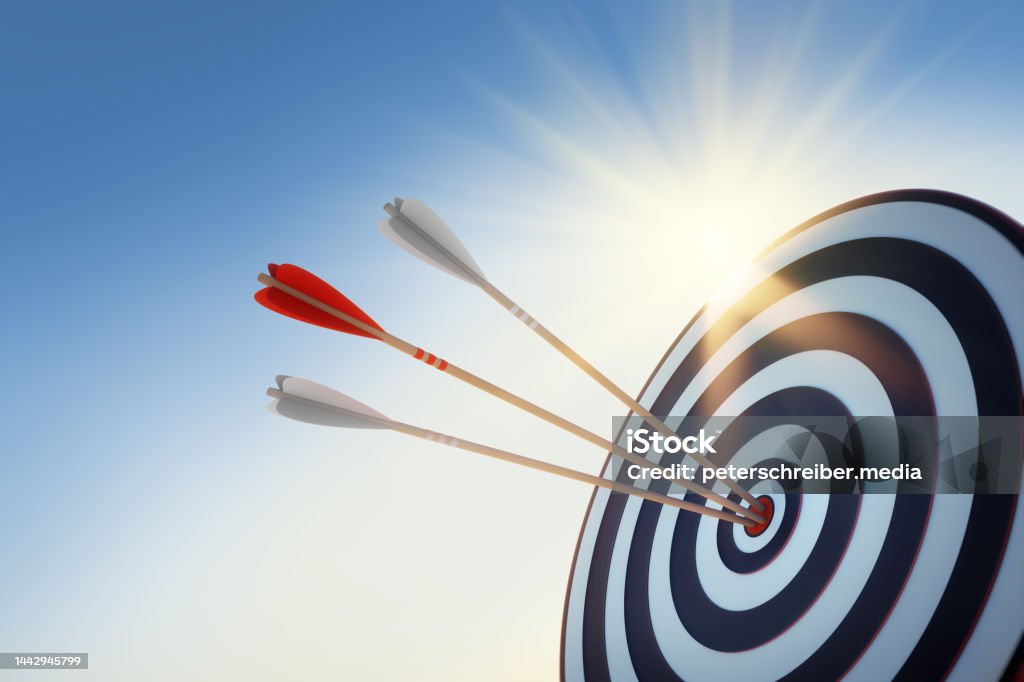 Archery target with three arrows Archery target with hits by three arrows with sun and sky with sun flares Three Objects Stock Photo