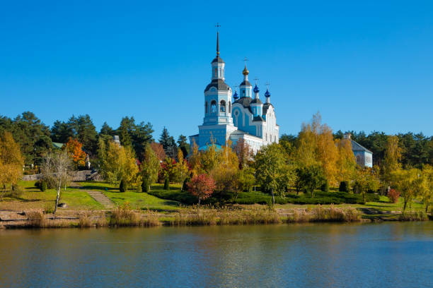 City recreation park with a pond and St Nicholas Cathedral. Autumn sunny day in Horishni Plavni city stock photo