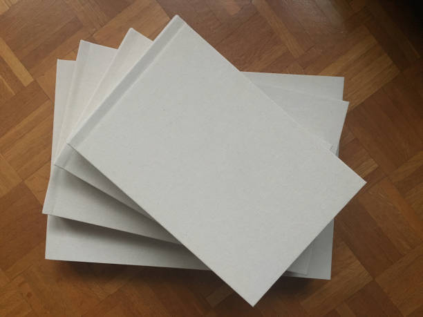 Stacked wedding albums on a wooden floor