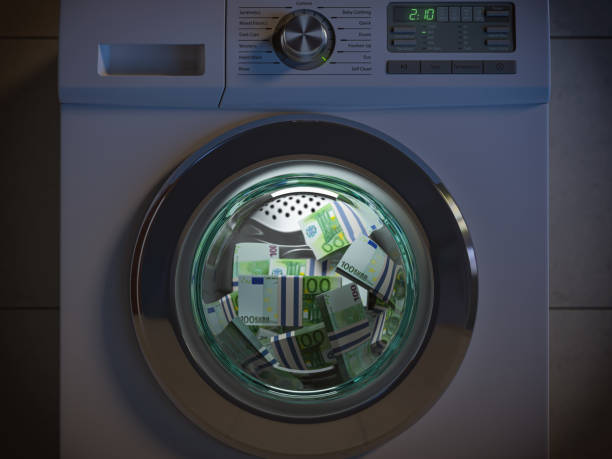 Dirty money laundering concept. Euro packs laundering in washing machine under clioud of night. stock photo