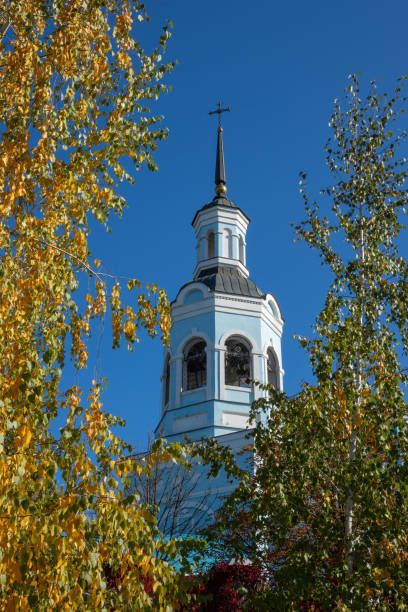 Cross on St. Nicholas Cathedral in autumn sunny day. Temple bell tower against the blue sky stock photo