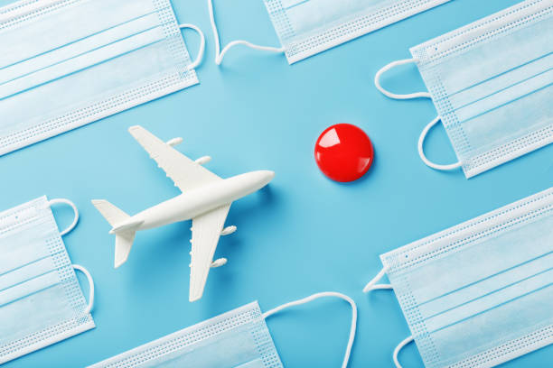 istock A toy white airplane and protective masks on a blue background with a red dot as the destination. 1442954003