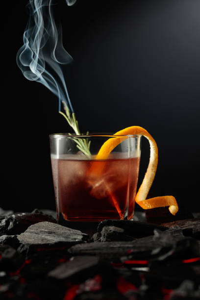 Old-fashioned cocktail  with a burning twig of rosemary. stock photo
