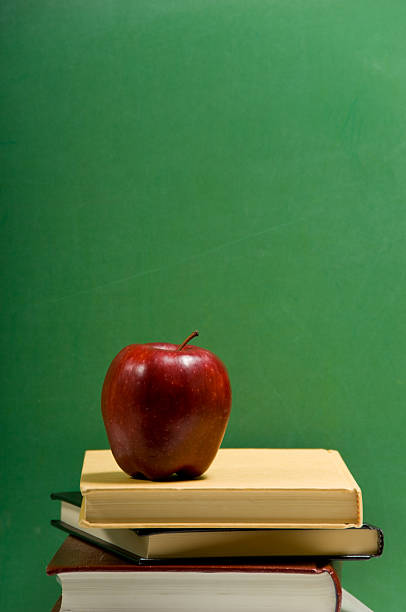 istock red apple on school books with green background 144296627