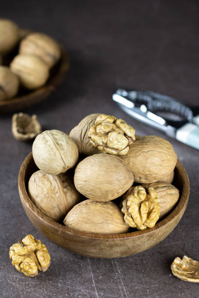 istock Walnut kernels and whole walnuts on a wooden table. View from above. Nuts and nutcracker on a wooden background. 1442968064