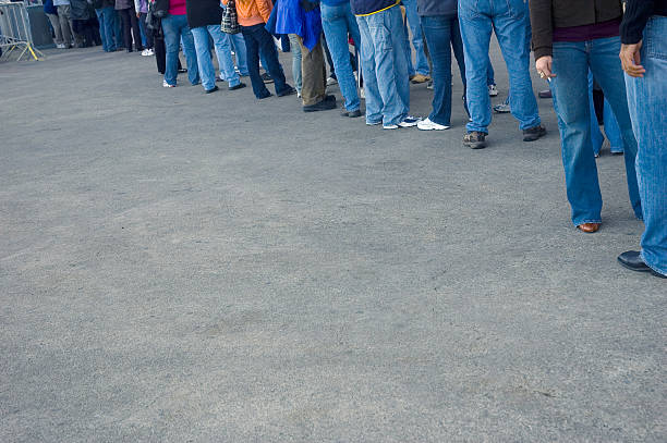 istock People all wearing jeans waiting in line 144297087