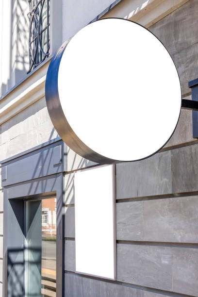 istock Mock up template. Blank round singboard and vertical white rectangular board of store, shop, restaurant, bar, office on classical style building wall outdoors 1442972613