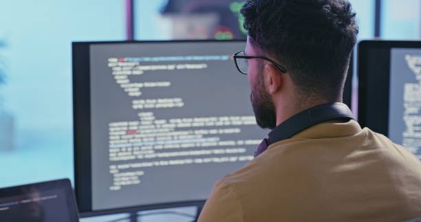 Computer coding, software development and programmer man writing code for cybersecurity analytics, seo data and digital cloud computing. Back of programmer, IT technician and web programming desktop stock photo