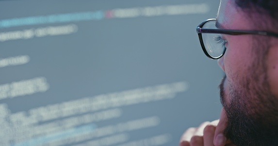 Man, programmer and code thinking for developing software, app or technology on screen. Male programming developer with glasses in thought during coding process for troubleshooting or debugging issue