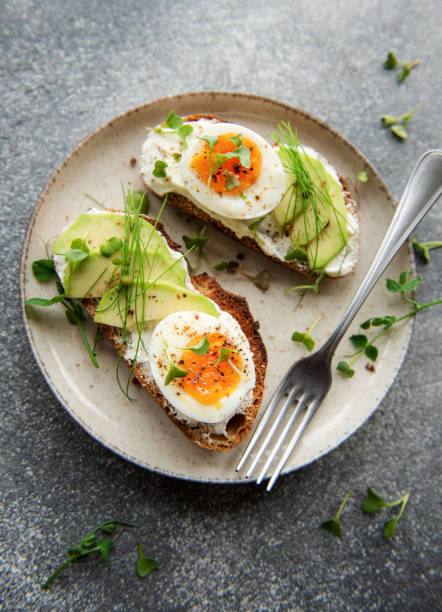 istock Bread toast, boiled eggs, avocado slice, microgreens on a plate 1442979826
