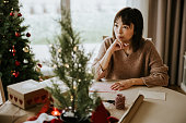家族にクリスマスカードを書く女性