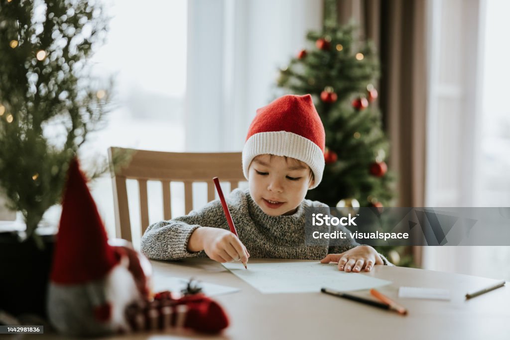 Boy writes a letter to Santa Clause Photo series of Japanese mother with her son preparing for Christmas holidays - sending Christmas letter to Santa Clause. Santa Claus Stock Photo