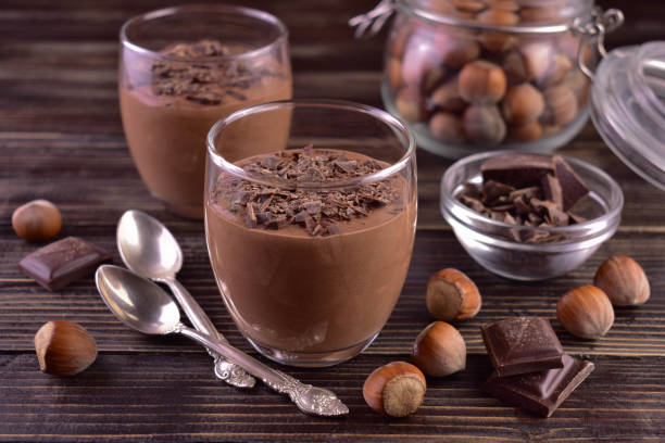 istock Chocolate mousse with hazelnuts in glasses on a dark wooden background. 1442984437
