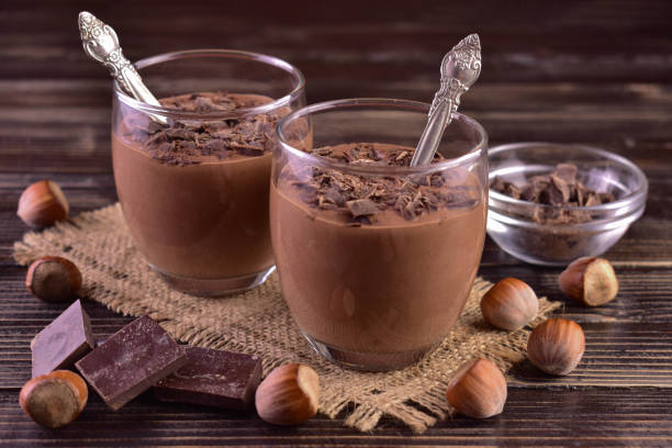 istock Mousse with dark chocolate with hazelnuts in glasses on a dark wooden background. 1442985092