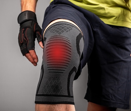 Athletes trauma, pain, injury of knee and elastic kneecap supporting bandage, sleeve on leg close up. High quality photo