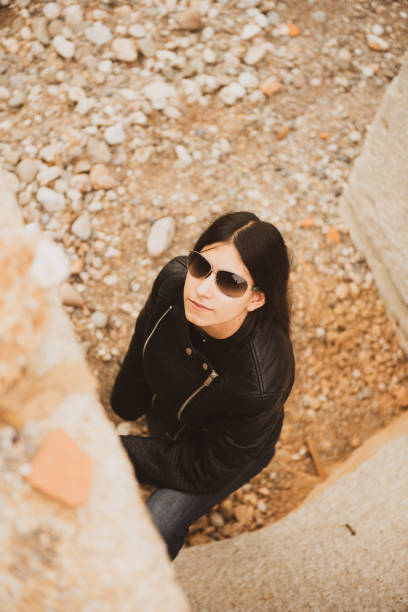 istock Woman with classic sunglasses on a cloudy day, dressed in a black leather jacket 1442990889