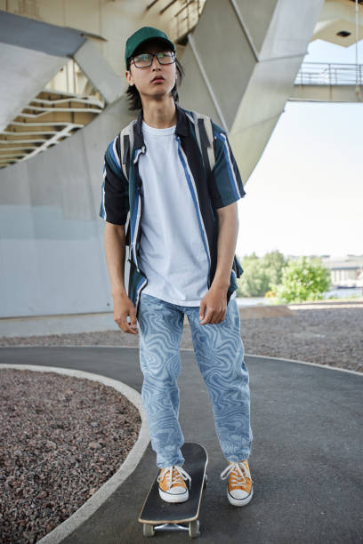 istock Asian young man skateboarding in urban setting 1442992443