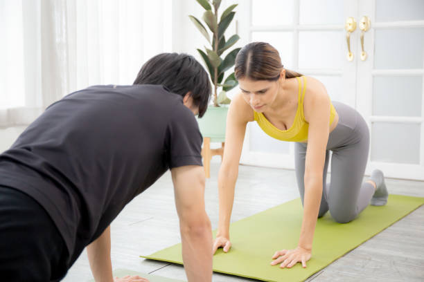 istock Young woman and man practicing workout with posing plank on mat while motivation and determined at home, female and male doing weight training with strength and strong, two people, sport concept. 1442992490