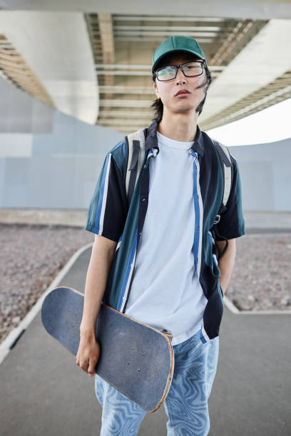 istock Asian man with skateboard posing outdoors 1442992511