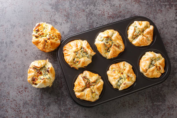 homemade feta cheese puff muffins with spinach closeup in the maffin pan. Horizontal top view stock photo